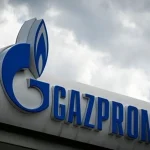 Логотип Газпрому на фасаді будівлі під хмарами