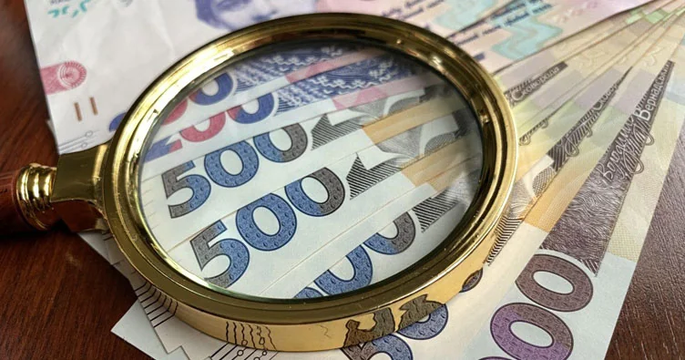 Лупа над банкнотами 500 грн під час розслідування ухилення БЕБ