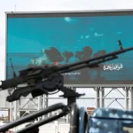 Озброєний хусит біля білборда з атакою суден у протоці Баб-ель-Мандеб