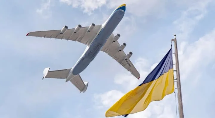 Літак Antonov у небі з прапором України як символ відновлення авіації