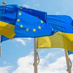 Прапори України та ЄС майорять разом на тлі неба під час вступу